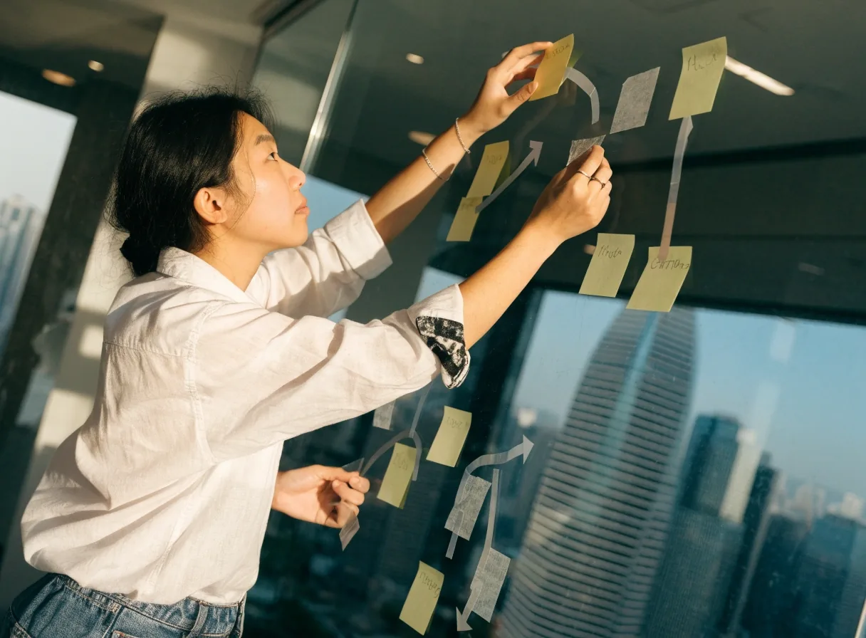 设计师在桌面上用空白卡片排列移动端操作流程的顺序